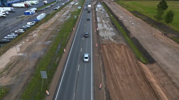 Aerial View of the Highway Going Through the Green Fields and Forests