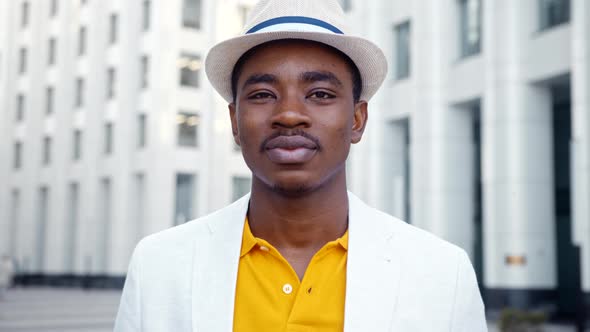 Cheerful black man in classic suit looks straight with white toothed smile