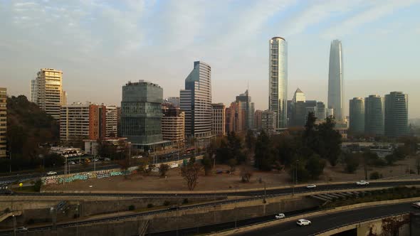 Aerial view passing above a highway with the city and skyscrapers as background in Chile