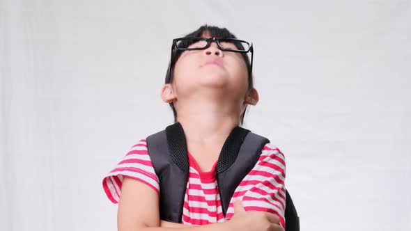 An upset schoolgirl stood with her arms crossed and looked at the camera