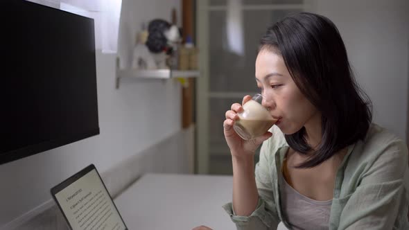 Asian writer with laptop and coffee at home