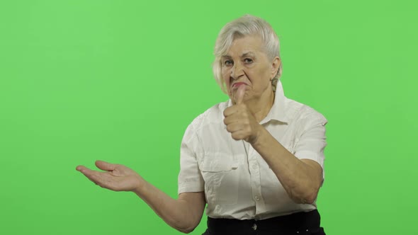 An Elderly Woman Points at Something and Smiles. Old Grandmother. Chroma Key