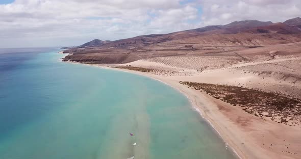 Vertical view of sand and beach with blue clean sea water. Tropical aerial landscape with waves