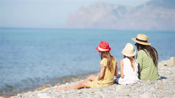 Adorable Little Girls and Young Mother on Tropical White Beach