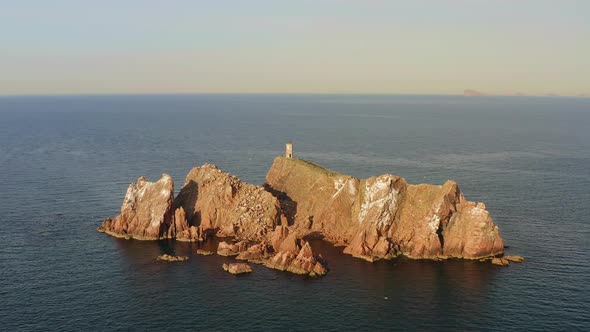 An Abandoned Lighthouse on Top of a Rocky Island at Sunrise