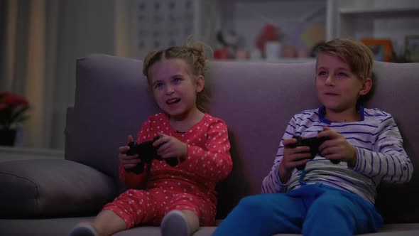 Two Children Playing Game With Joysticks Caught Parents at Night, Entertainment
