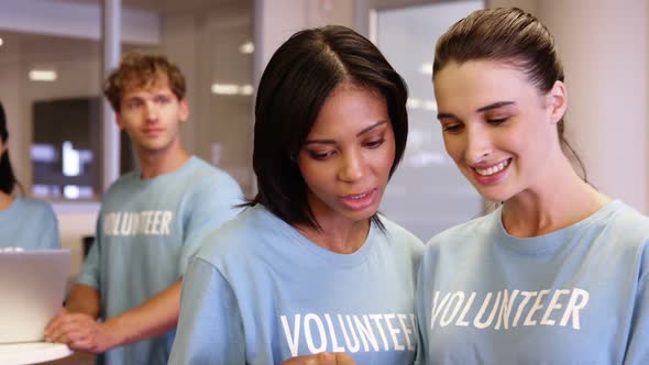 Two female volunteer using digital tablet