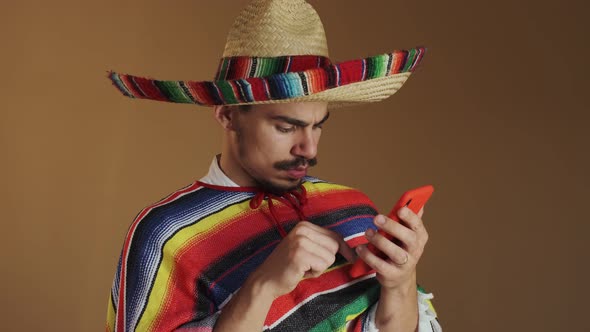 Young Mexican In Multicolored Poncho And Hat