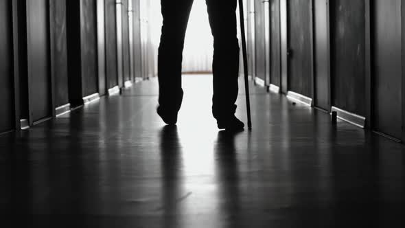 Man Limping along Hospital Corridor