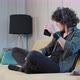 Curly Haired Young Man on the Couch Listening Music with Headphones - VideoHive Item for Sale
