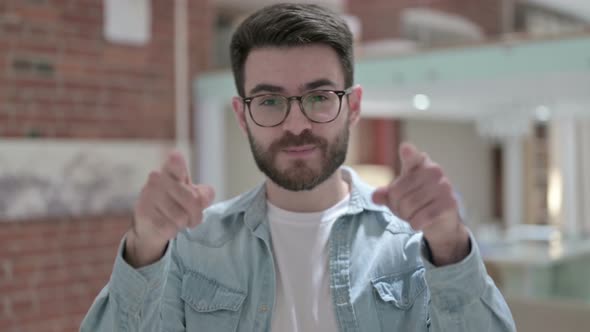 Portrait of Young Male Designer Pointing Finger at Camera and Inviting 