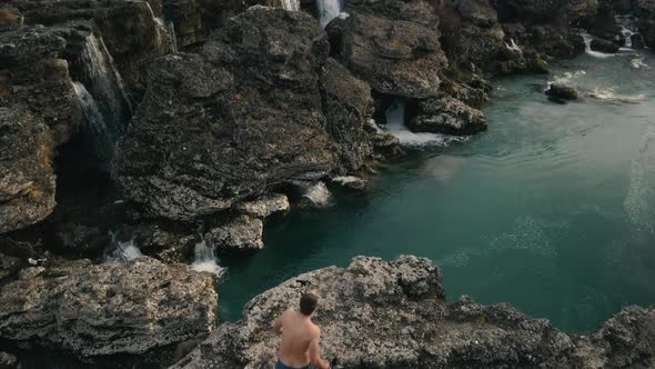 Aerial view Young man in jeans jumps in the canyon of Niagara Waterfall on the river Cijevna