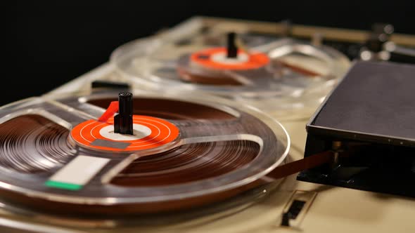 Vintage Reel to Reel tape recorder playing music close up of reel