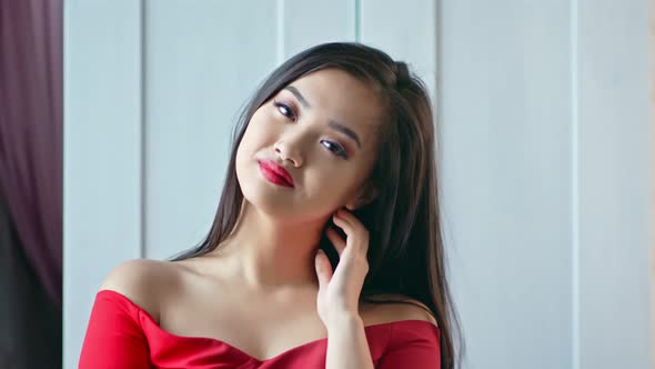 Portrait of Sexy Fashion Young Asian Woman Wearing Red Dress and Evening Makeup Smiling