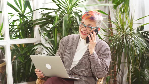 Funny Businesswoman Sitting in Business Center with Laptop and Smartphone