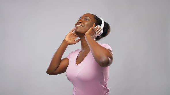 African Woman in Headphones Listening To Music