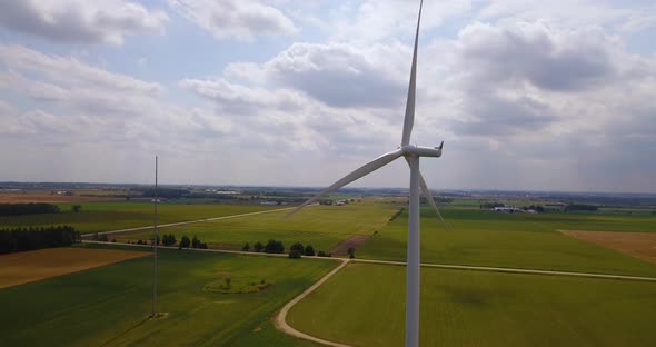 Static aerial shot of a rotating wind turbine