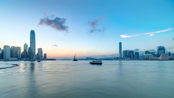 Hong Kong China Skyline Panorama with Skyscrapers Day To Night From Across Victoria Harbor Timelapse