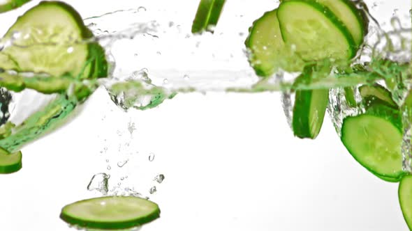 Super Slow Motion Pieces of Fresh Cucumbers Fall Into the Water with Splashes