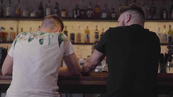 Two Men Sitting at the Bar Counter Drinking Elite Alcohol