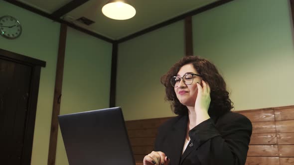 A Young Woman is Talking Over a Video Link Using Her Laptop