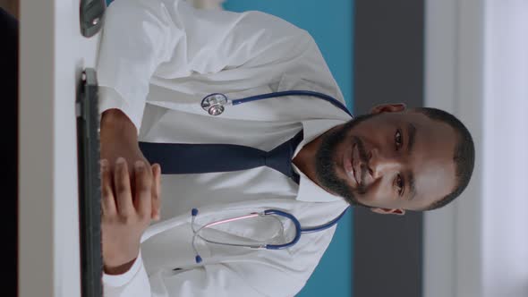 Portrait of African American Physician Doctor Sitting at Desk Analyzing Disease Diagnostic Report