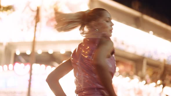 Woman In Pink Pvc Clubwear Spinning And Posing To Camera By Neon