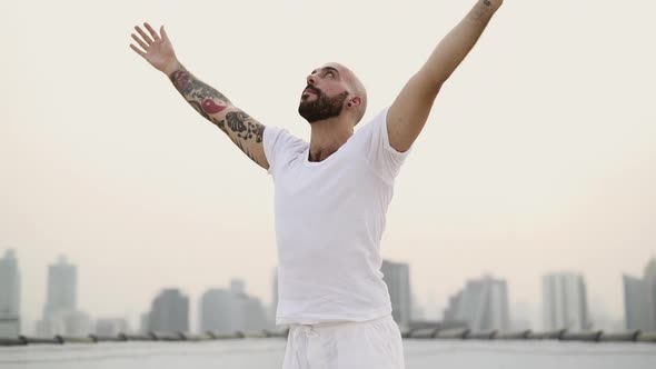 Bearded Male Stretching His Arms On A Circular Downwards Movement