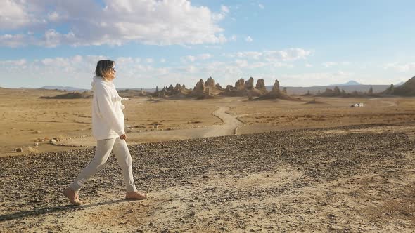 Happy Tourist Walking By Cinematic Salt Lake with Trona Pinnacles on Background