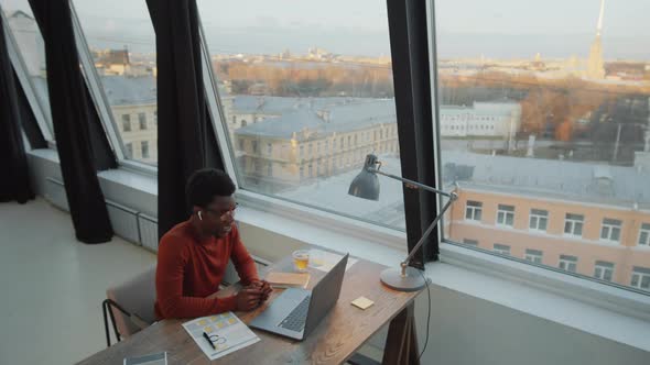 Afro Businessman Web Conferencing on Laptop in Rooftop Office