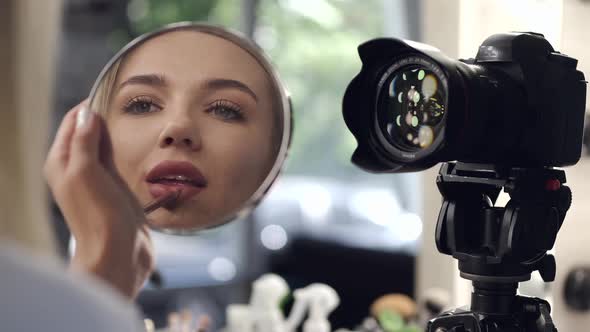 A Pretty Makeup Artist Is Applying Lipliner on Her Lips Looking in a Mirror