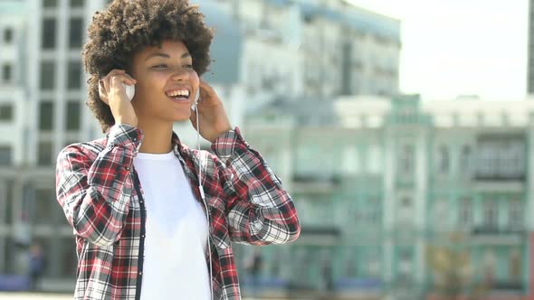 Playful Girl in Headset Enjoying Favorite Music, Dancing Outdoors, Slow-Motion