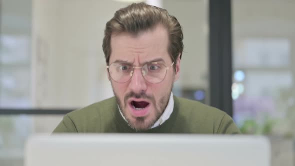 Close Up of Young Businessman Reacting to Loss on Laptop