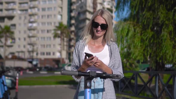 Woman unlocks electric scooter app with her smartphone.