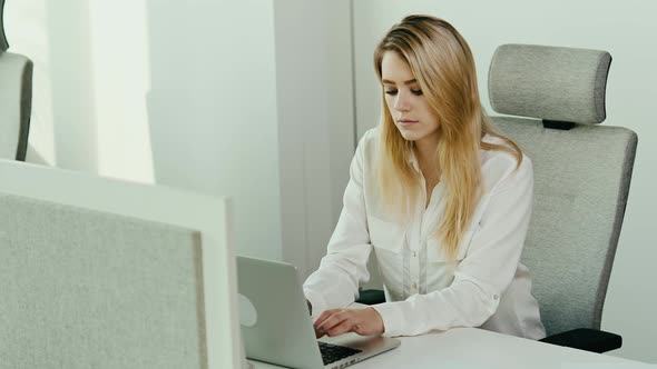 young businesswoman is working on the computer in a bright office