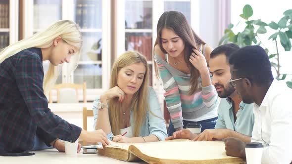 Mixed-race Group of University Students Doing Linguistic Researches, Turning Over the Pages of Big