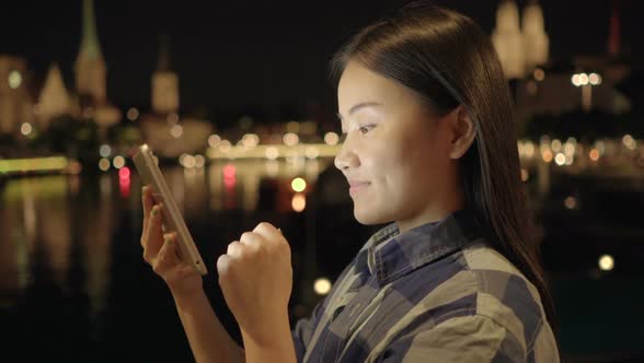 Young Asian Woman Using Digital Tablet Screen in the City