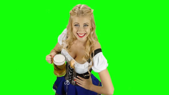 Bavarian Girl with a Glass of Beer in His Hand Flirts. Green Screen