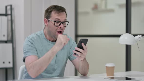 Young Man Celebrating Success Smartphone Work