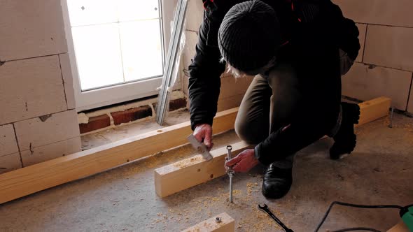 Hands of master twist washer with nut onto a threaded steel stud into concrete floor of rough floor