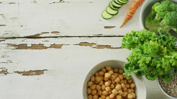 Video of bowls of fresh vegetables with copy space over white rustic background