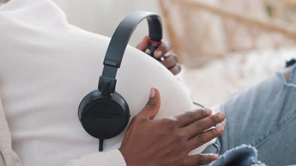 Unrecognizable African American Woman Expectant Mother Wears White Clothes Holding Headphones on