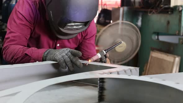 Worker Welding Work on metal sheet.