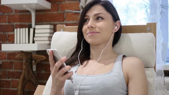 Young Woman Listening Music on Smartphone Headphones