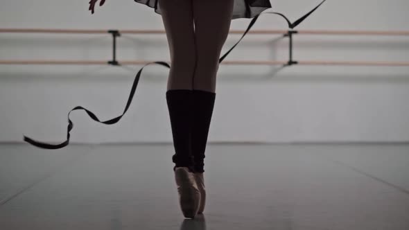 Closeup of Ballerina Feet in Pointe Shoes and Black Dress Dancing Ballet Elements Slow Motion