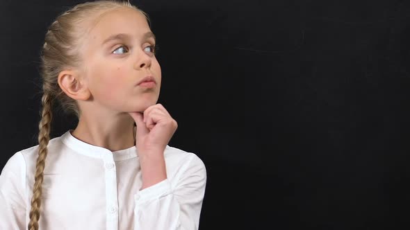 Thoughtful Little Girl Touching Chin and Looking to Side, Template for Text