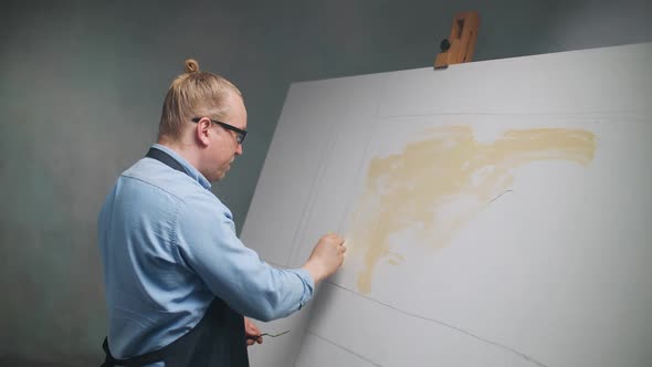 Slow Motion Creative Person at Work a Talented Adult Man Artist Covers the Canvas with Beige Oil