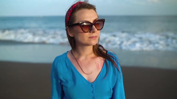 Portrait of a Woman in a Beautiful Blue Dress on a Black Volcanic Beach