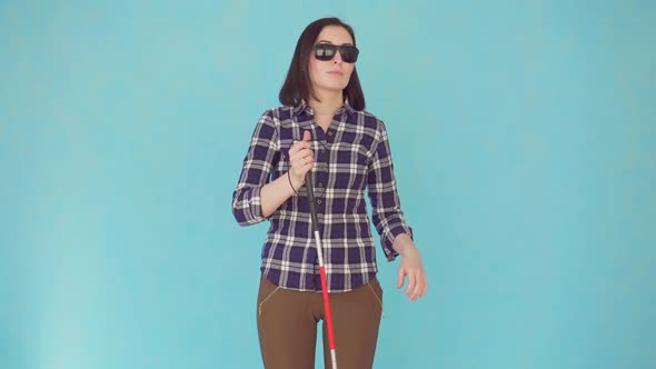 Smiling Blind or Visually Impaired Young Woman with Glasses and a Cane