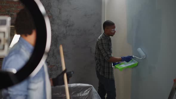 Black Decorator Paints Wall Recording Video for Social Media